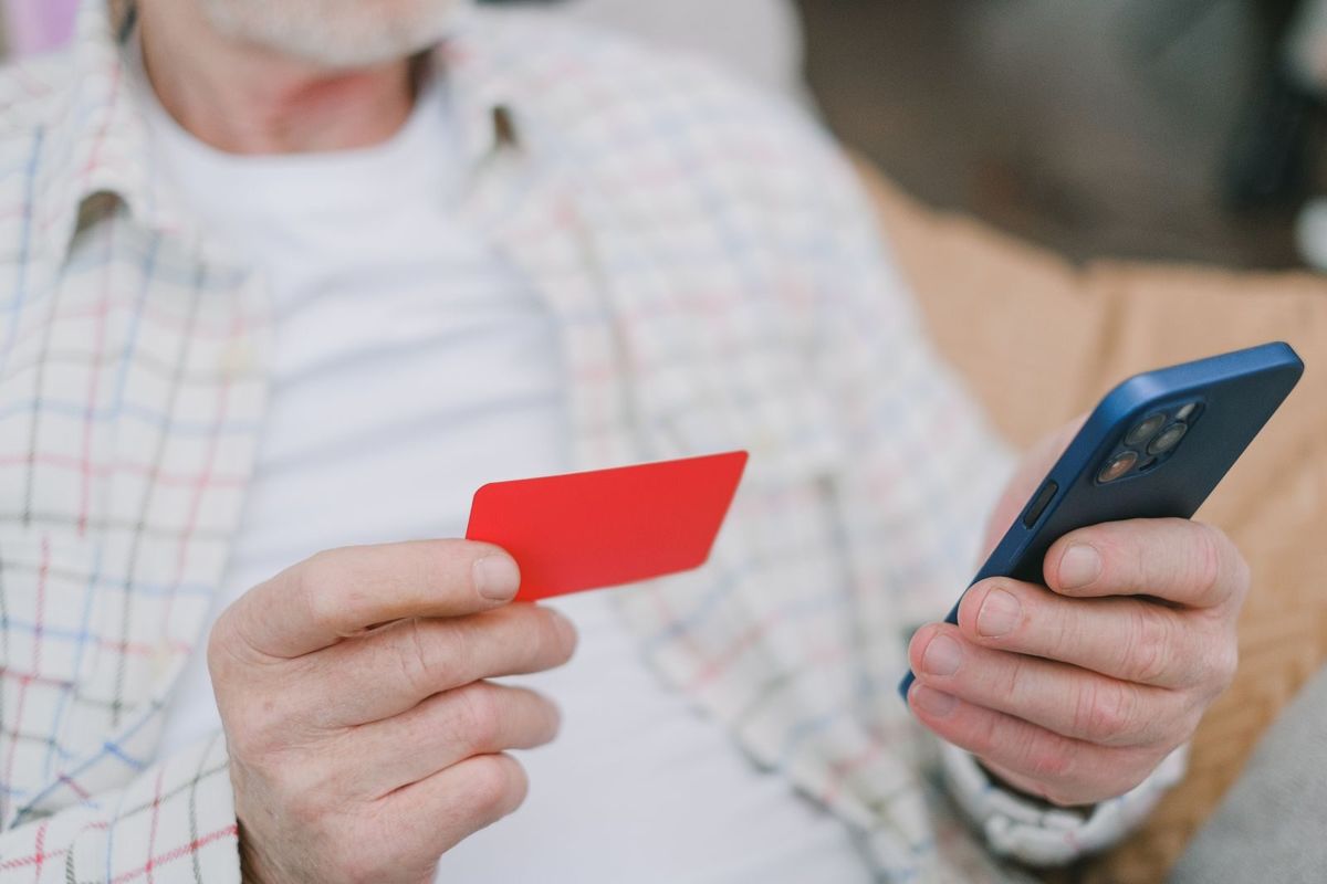 Hands holding a bank card and a phone